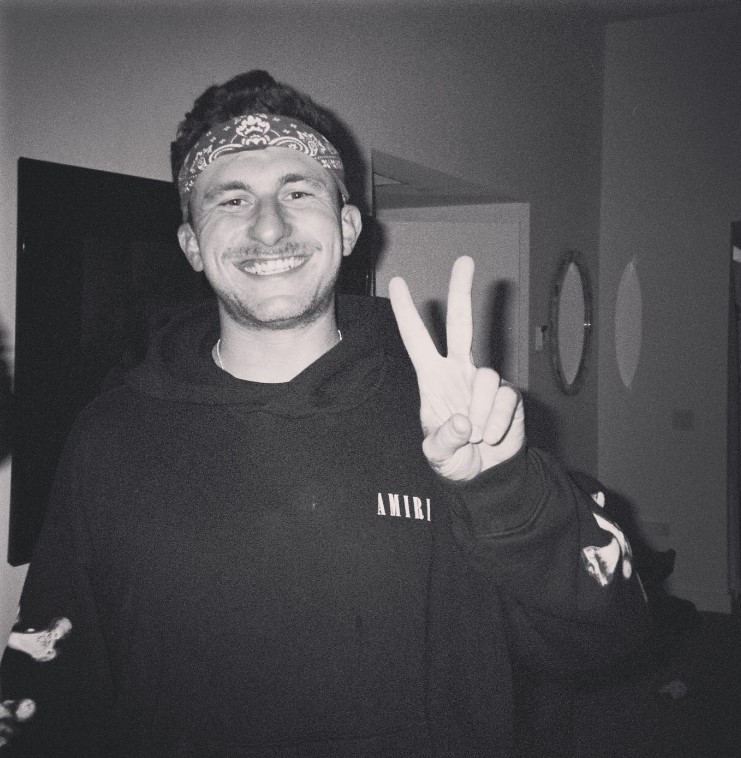Johnny Manziel smiling with his fingers in a peace sign