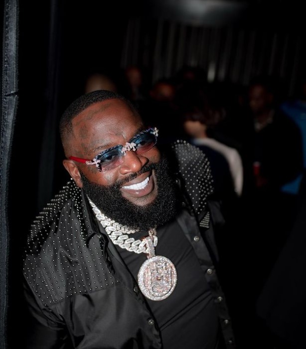 Rick Ross, smiling and wearing black