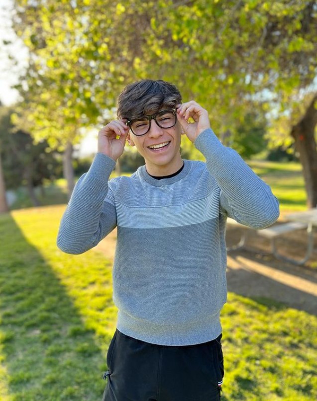 Ayden Mekus in glasses and a sweater