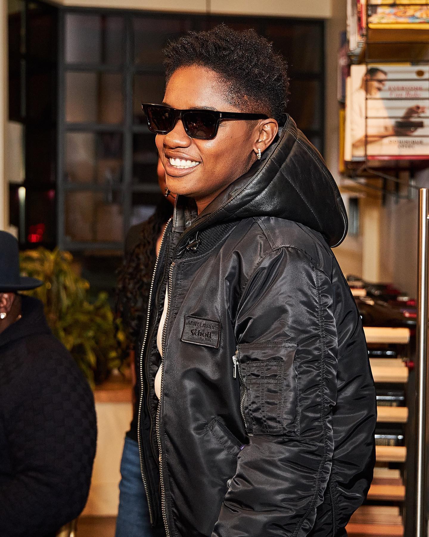 Bre-Z, smiling and wearing sunglasses and black jacket