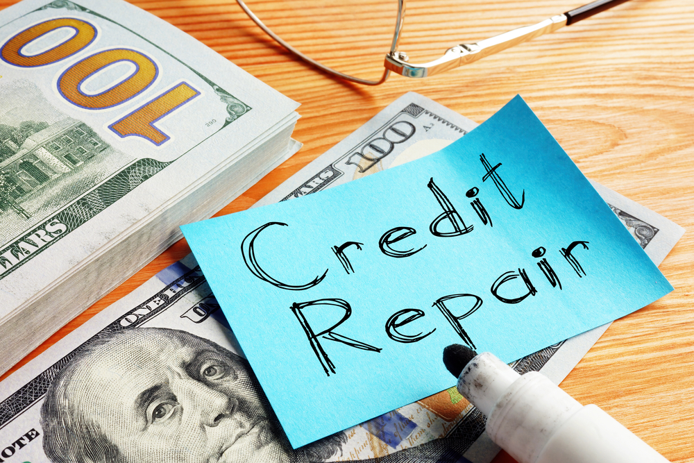 credit repair written on blue paper and placed over us 100 dollar currency note