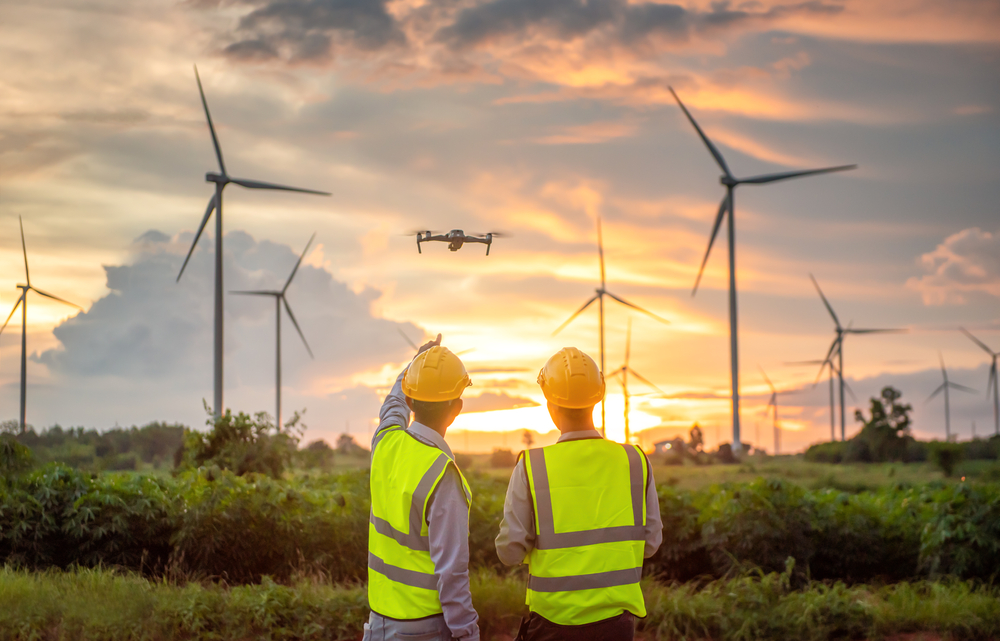 two engineers flying drone for surveying to checking wind turbines