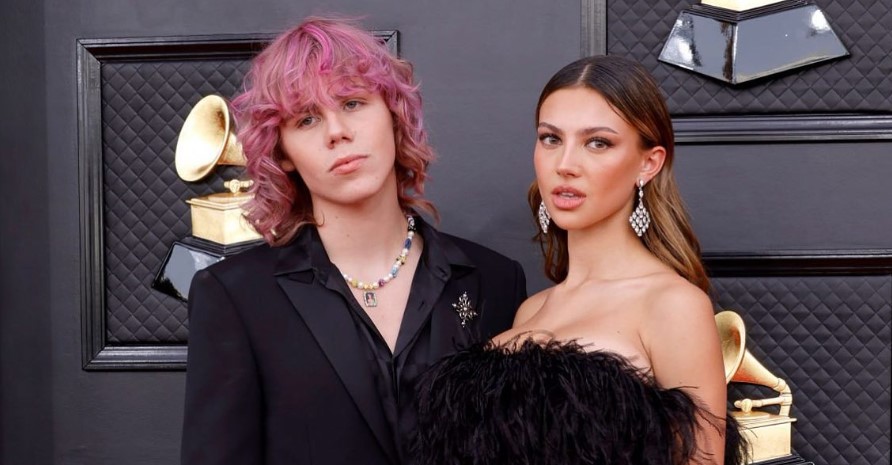 The Kid Laroi with pink hair, standing next to his girlfriend