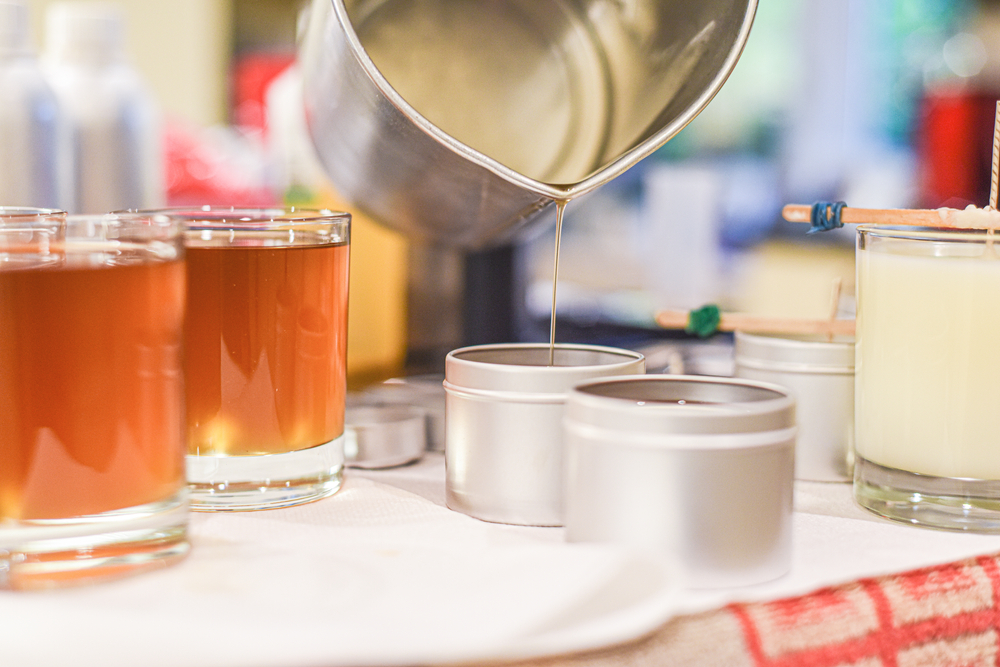 pouring of liquid wax into jars for candle making