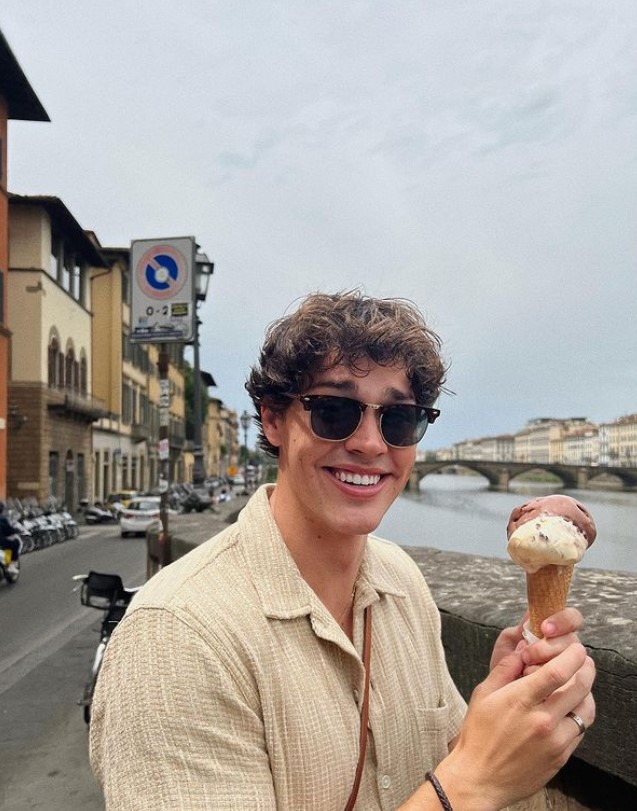 Noah Beck wearing sunglasses, smiling with gelato in Florence, Italy