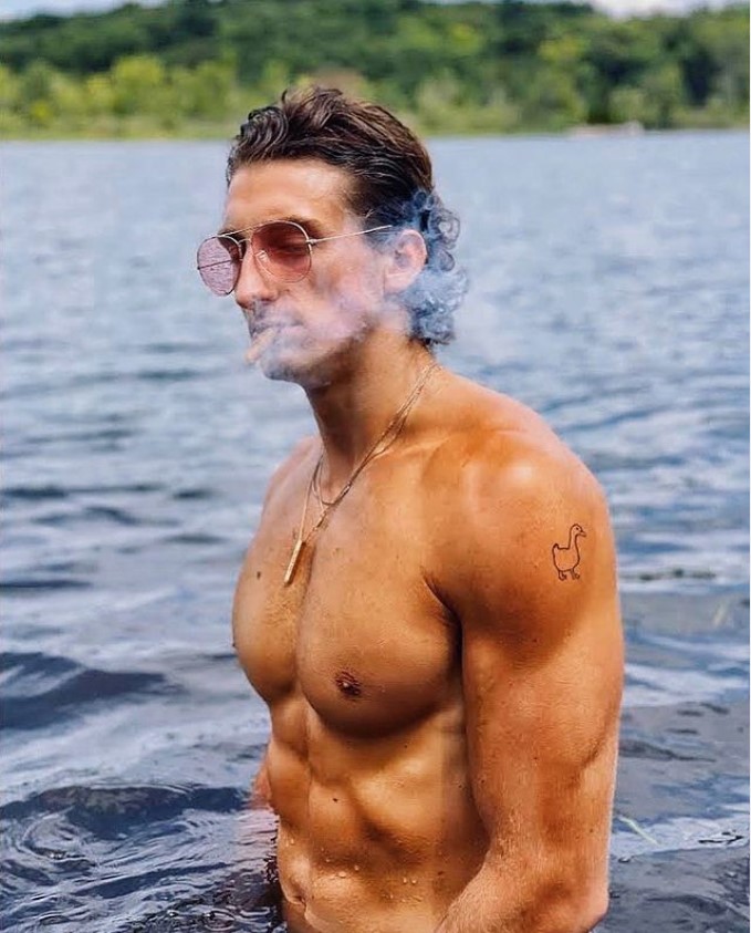 TooTurntTony, shirtless by the water, smoking