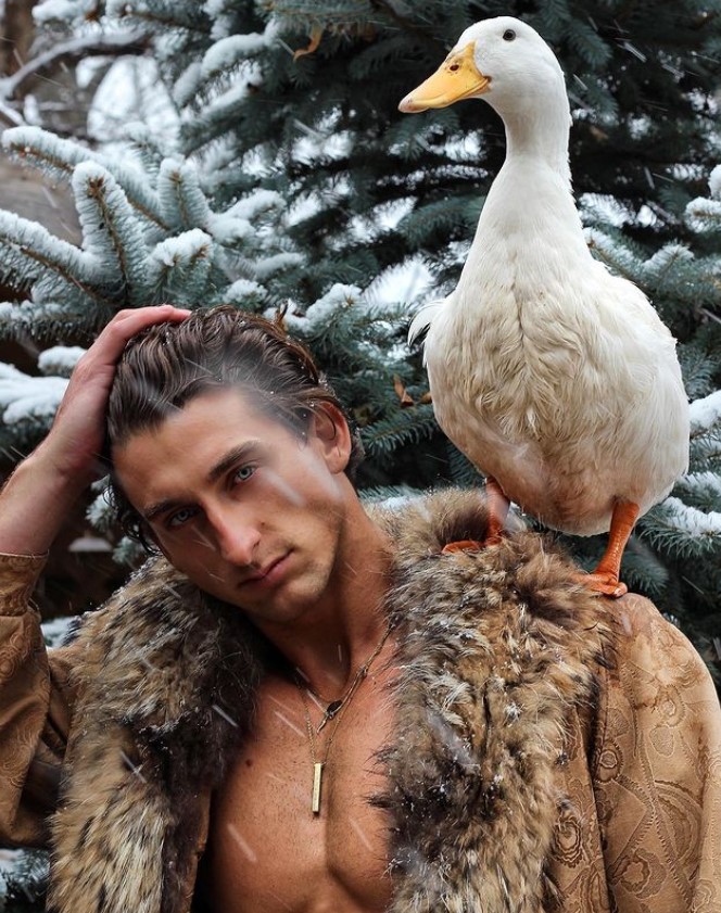 TooTurnt, against a backdrop of snowy trees and a white duck on his shoulder