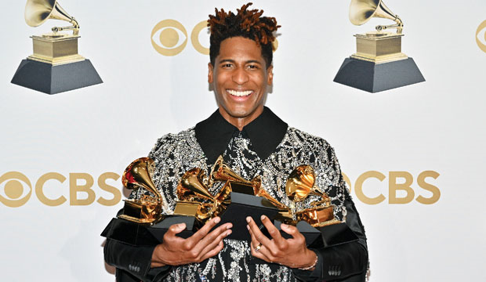 Jon Batiste holding his five 2022 Grammy trophies